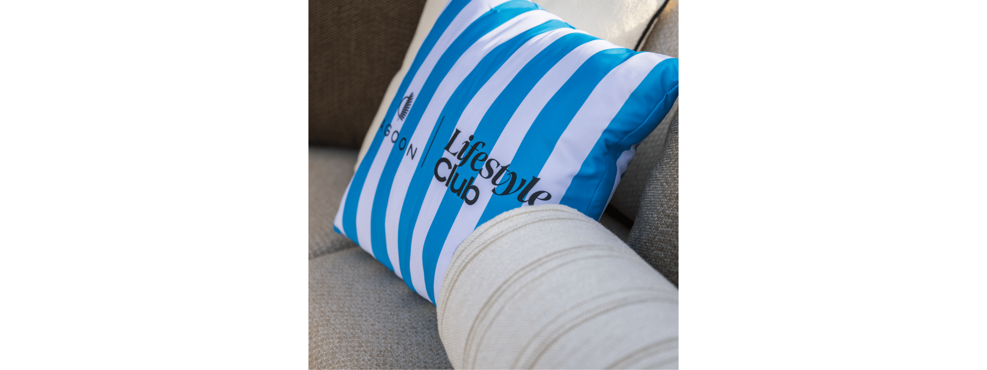 A cushion embroidered with the Lagoon Lifestyle Club logo